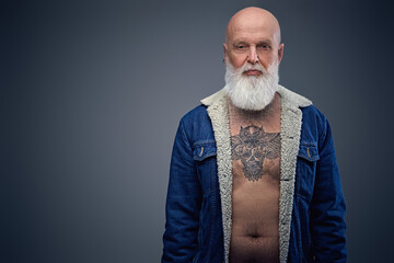 Portrait of aged man with naked tattooed chest dressed in trendy warm jacket.