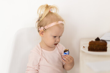 Funny baby with cochlear implant sitting at home and eating. Hear aid and medicine innovating technology concept