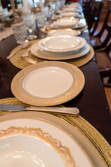 Formal dinner place setting. White china with gold trim and chargers on mahogany table. Sunbury Plantation House, Barbados. Restored great house from gentry time of the island's sugar barons.