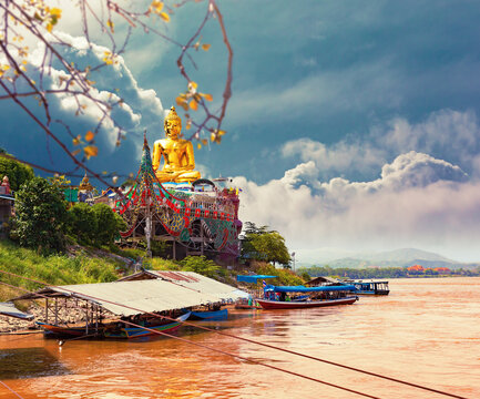 Estatua dorada de Buda gigante en el río Mekong. Hermoso amanecer en el río Mekong con barcos, frontera entre Tailandia y Laos, Tailandia.