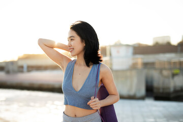 Fototapeta premium Beautiful young woman stretching outside. Fit woman doing yoga exercise.