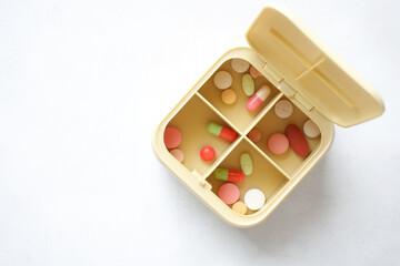 close up of medical pills in a pill box on table 