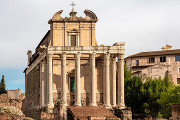 Obraz premium Panoramic close up view of the Antoninus and Faustina Temple in the Roman Forum (Foro Romano) in the city of Rome, Lazio, Italy, EU Europe. Ancient ruins of the Roman Temple on Via Sacra. Culture trip