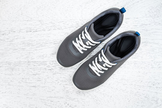 Active healthy living concept: running shoes on white wooden background. Top view. Copy space.