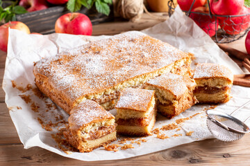 Homemade pie with apples and cinnamon on rustic wooden background