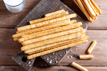 Italian grissini or salted bread sticks tied with rope on table. Top view.