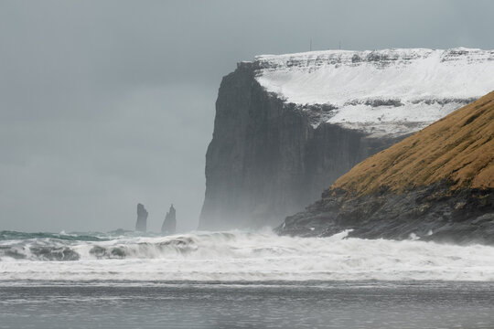Une falaise enneigée de 350 mètres aux îles féroé pendant l'hiver