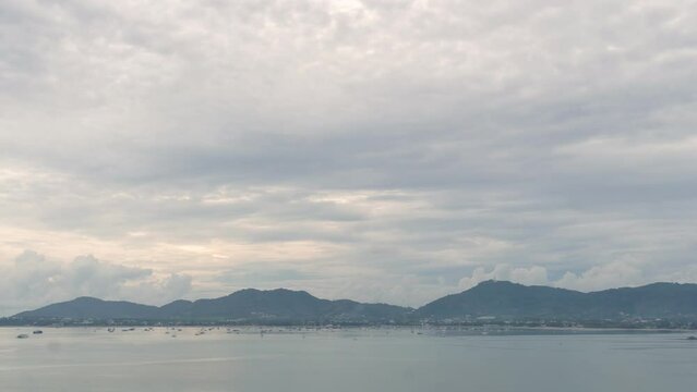 
time lapse cloudy sky above the mountain range.
At Khao Khad viewpoint you can see around Ao Chalong gulf. 
Phuket big Buddha on the mountain backgroud.
