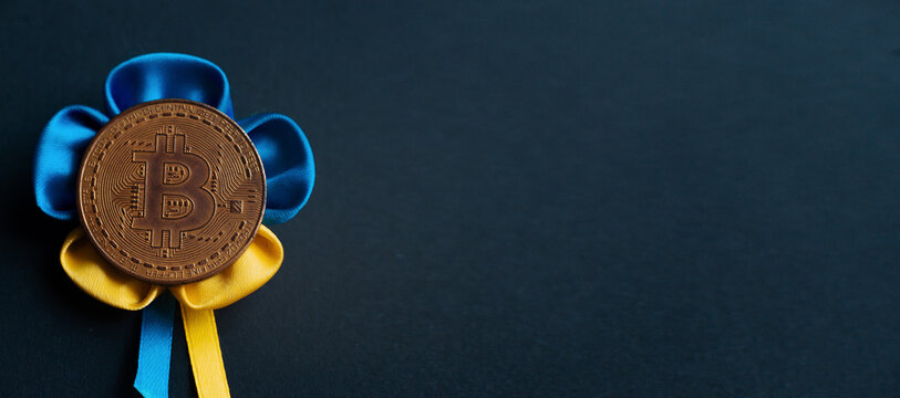 Bitcoin on a black background with the Ukrainian ensign. Concept