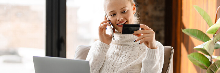 Happy smiling blonde white woman shopping online