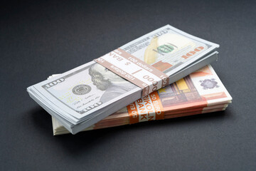 A pile of American money banknotes with European cash banknotes, stacks of US dollars, 100 $ one hundred dollars and 100 euros 50 euros