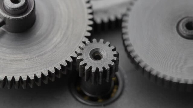 Gears rotating in a mechanical device. Machine metal gears rotating abstract. Cog wheels machinery, close up, macro