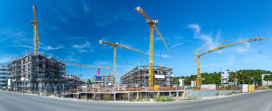 Widescreen panorama shot of large construction site with cranes and foundations