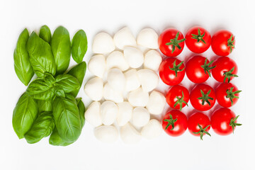 Italian flag made of food. Italian caprese salad made of cherry mozzarella, basil leaves and cherry tomatoes on white background. 