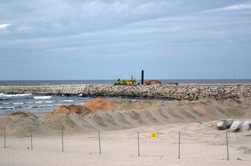 Widok na morze i sprzęt budowlany pogłębiarki do wybierania piasku z dna 
