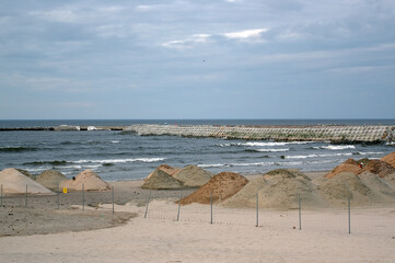 Zwały piasku i kamieni na plaży na budowie przekopu