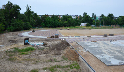 construction of a new stadium near the city school. earthworks and foundation pouring for playgrounds are being carried out