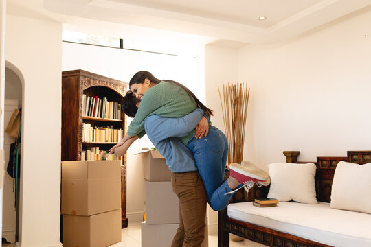 Excited Happy Young Asian Couple Hugging In New Apartment