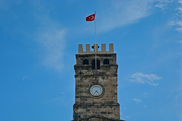 castle shaped clock tower in turkey, turkish flag