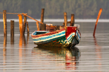 Colorful wooden boat on calm water of Gambia River in Mansa Konko Province in the Gambia.