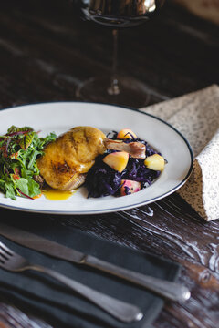 Duck Leg On A White Plate With Salad And Fresh Vegetables