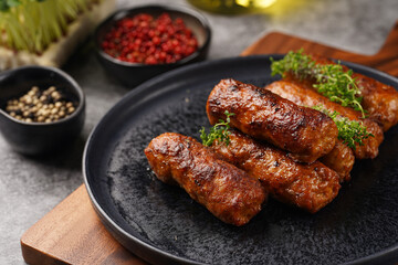 Traditional south european skinless sausages cevapcici made of ground meat and spices on black...