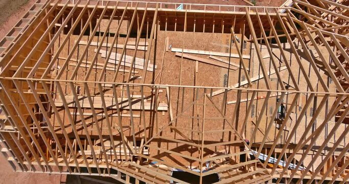 Aerial view of framed home roof system with wooden timber beams roofing atic ceiling