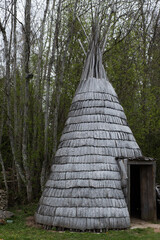 Wooden tipi in historic village. Conical light wooden medieval building with fireplace in the middle. © Cloudy Design