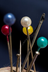 Close up of some different tailor's needles on blue jean background 