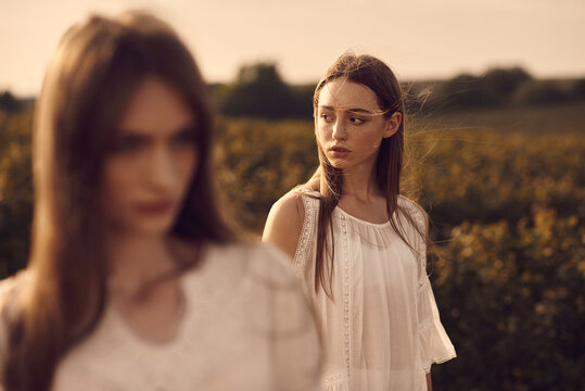 A Portrait Of Two Beautiful Women Models Among Green Field