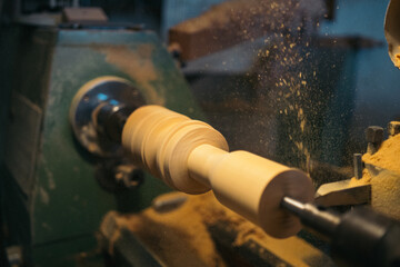 Lathe carving wooden piece in workshop