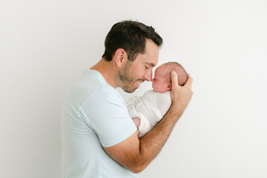 Father going nose to nose with newborn son