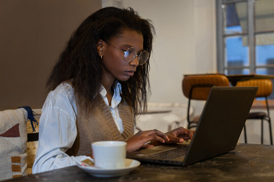 focused confident black woman working on computer, freelancer