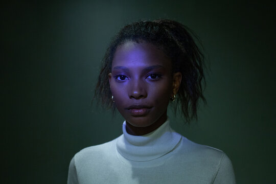 strong confident black woman in blue light, studio, looking at camera