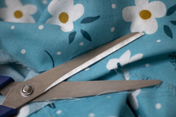 scissors and blue fabric with flowers