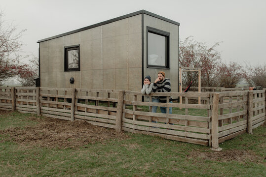 Couple standing by the tiny house