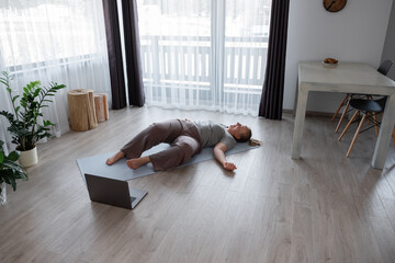 Woman doing Supine Spinal Twist on floor