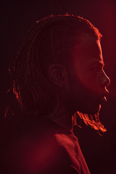 Black man with stubble under red light