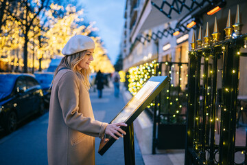 Woman searching information on touch screen kiosk