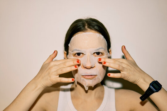 Young woman with a tissue mask on her face