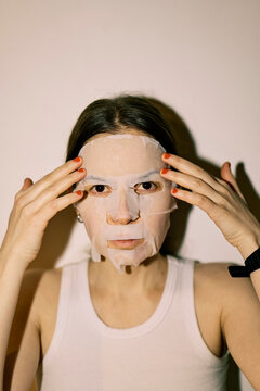 Young woman with a tissue mask on her face