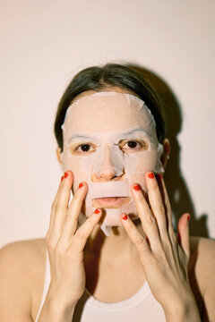 Young woman with a tissue mask on her face