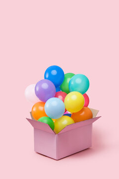 Cardboard box full of colorful helium balloons
