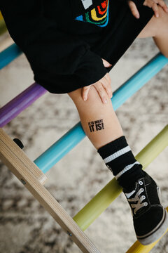 A picture of a kid's leg with a word tattoo
