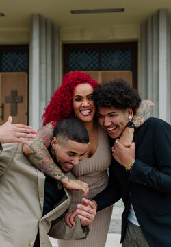 Laughing mom hugging grown sons