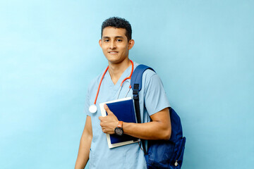 medical student with backpack holding books looking at camera.