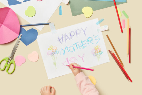 Child painting with colorful pencils greeting card for mom