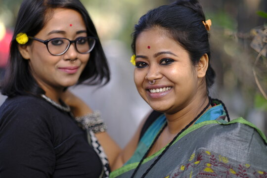 Two young lady wearing traditional Indian sari  and looking at camera