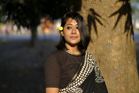 Indian woman portrait standing beside a tree at outdoors in evening
