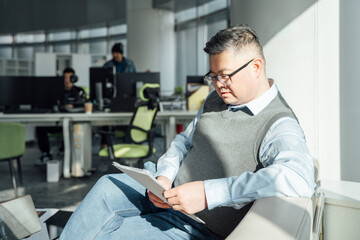 Portrait of Chinese man looking at document in office